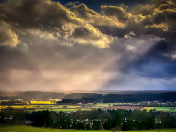 Sommerlandschaft in dramatischer Vorgewitterbeleuchtung mit heftiger Bewölkung und durchdringenden Sonnenstrahlen